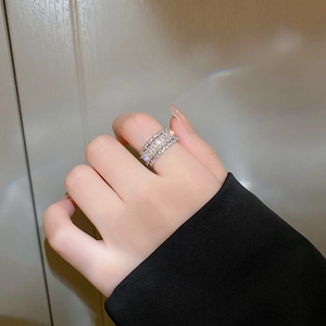 Close-up of sparkling cubic zirconia rectangle cut stones on a silver tiered band ring