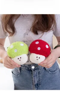 Close-up of cute red and green plush mushroom charms with smiles and metal keychains