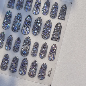 Makroaufnahme irisierender Gothic-Nagelaufkleber mit kunstvollen Glasfenstermustern