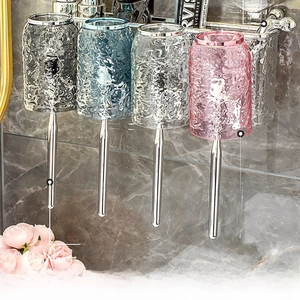 Detail of wall-mounted rack with four hammered glass cups and metal hooks in the bathroom