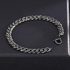 Vintage stainless steel Cuban link bracelet for men displayed on a black jewelry box