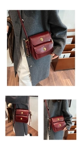 Detail showing vintage wine red crossbody bag with dual gold twist locks and tassel