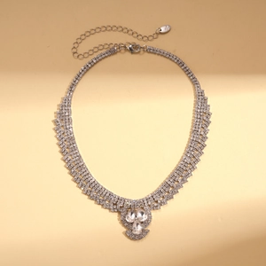 Détail macro du collier argenté avec pendentifs goutte d'eau et cristaux scintillants