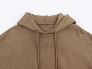 Detail view of the brown knitted hoodie neckline with drawstring and hood texture