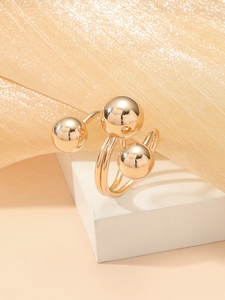 Detailed view of the triple-layer gold ring featuring polished metallic spheres