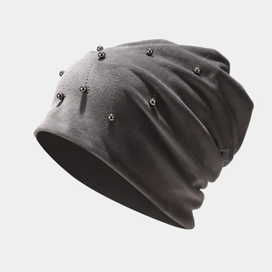 Detail of dark grey velvet beanie featuring vertical pearl and rhinestone embellishments