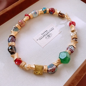 Close-up of vintage ceramic flower necklace with colorful geometric beads in a jewelry box