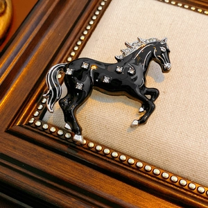 Macro detail of vintage horse brooch with black enamel and sparkling cubic zirconia