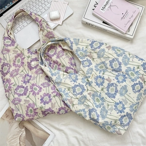 Flat lay detail of floral canvas tote bags with delicate purple and blue patterns