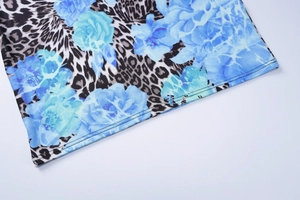 Détail de robe d'été avec imprimé floral bleu et léopard, mettant en valeur l'ourlet