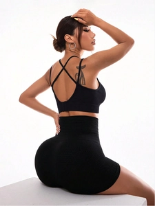 Detail of high-waist black gym shorts with honeycomb texture and cross-back sports bra