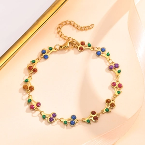 Detailed close-up of golden cherry bracelet with colorful glitter charms and lobster clasp