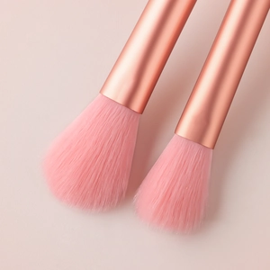 Detailed view of makeup brushes with pink bristles and rose gold metallic handles