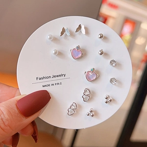 Close-up of 8-pair silver earring set with butterfly, pearl and rhinestone heart charms
