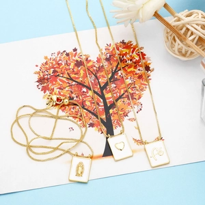 Detailed view of gold square pendants with Virgin Mary, heart, and faith motifs on box chains