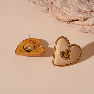 Boucles d'oreilles cœur vintage beige avec logo Saturne doré et finition émail