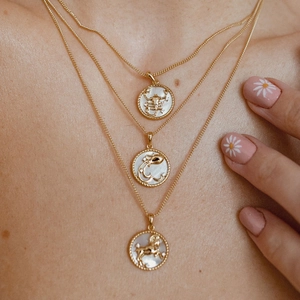 Layered gold zodiac coin necklace with mother of pearl inlays and shell medallions