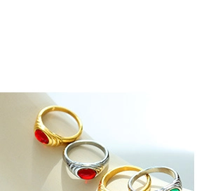 Detail of vintage stackable rings featuring retro gemstones and textured gold plated metal