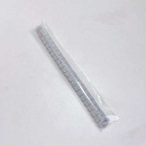 Detail shot of a grey bohemian hand-woven cotton curtain tieback in clear packaging