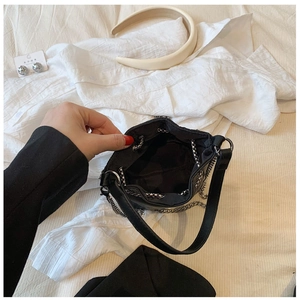 Macro view of the black bucket bag interior with drawstring closure and silver chain