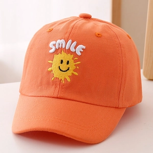 Close-up of bright orange kids baseball cap featuring white SMILE embroidery and sun face