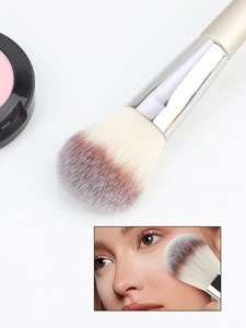 Detail of fluffy champagne makeup brush with soft gradient bristles and silver ferrule