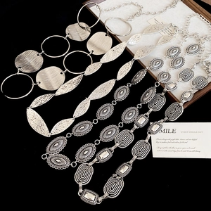 Detailed close-up of antique silver oval waist chains with bohemian engraved patterns