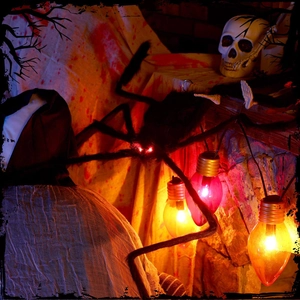 Close-up of Halloween giant spider with glowing red eyes and spooky skull decor