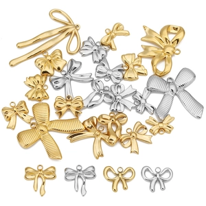 Gold and silver stainless steel bow pendants for DIY jewelry making on white background