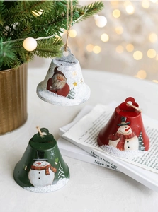 Close-up of rustic Christmas metal bells featuring Santa and Snowman motifs with twine loops