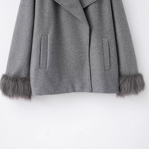 Manteau élégant en laine grise avec poignets en fourrure pelucheuse et poches à rabat