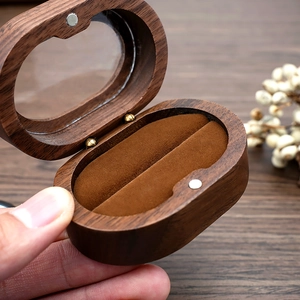 Detail of walnut wood ring box with velvet lining and transparent magnetic lid