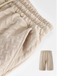 Detail of men's beige shorts showing textured jacquard fabric and drawstring waistband