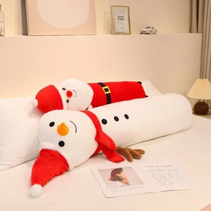 Long Christmas plush pillows featuring Santa Claus and snowman designs on a white bed