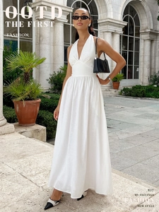 Detail view of a white halter V-neck cotton maxi dress with waist tie and flowy skirt