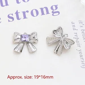 Detail of silver alloy bow pendant with purple square rhinestone for DIY jewelry making