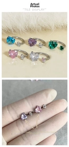 Detail of heart-shaped zircon piercing studs with screw back in multiple colors