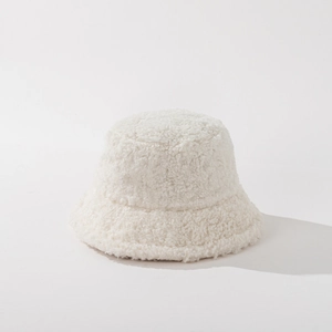 Close-up of soft white plush bucket hat fabric showing warm fluffy faux fur texture