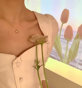 Elegant 3D golden heart pendant necklace on model with minimalist aesthetic style