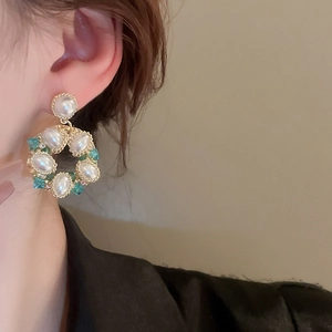 Close-up of vintage flower earrings with pearls and turquoise on a model