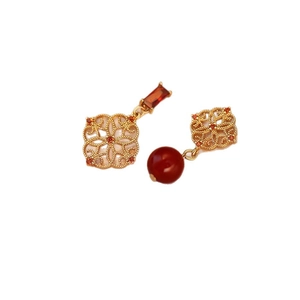 Elegant hollow flower stud earrings with red square gemstones and gold-tone finish