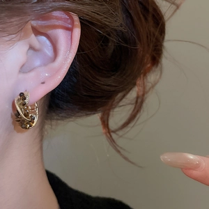 Detail of vintage tiger eye stone beads on gold-plated C-shaped hoop earrings