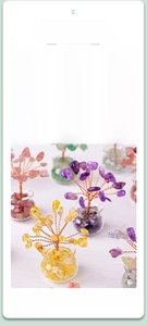 Detailed macro view of handmade natural crystal money trees in assorted healing stones