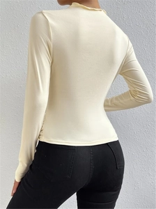 Detalle del cuello alto con volantes y vista trasera de la camiseta ajustada beige manga larga