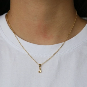 Minimalist 18k gold-plated brass bubble letter J pendant necklace worn by a model