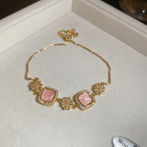 Détail d'un bracelet ajustable plaqué or 18 carats avec pierres roses et fleurs