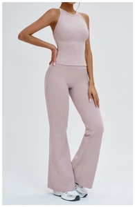 Détail du pantalon de yoga évasé à taille haute en tissu élastique rose poudré