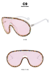 Detail view of pink shield sunglasses with colorful rhinestones on frame side and front