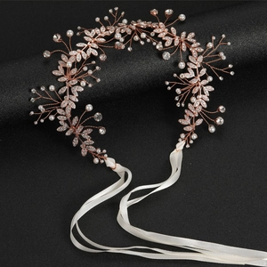 Macro detail of handmade rose gold bridal belt with white pearls and sparkling rhinestones