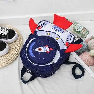 Flat lay of blue rocket backpack for kids with red wings and space theme design
